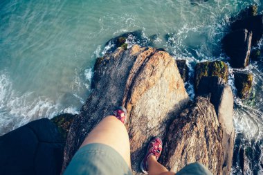 insan bacaklar seaside adlı rock uçurumun kenarında durun