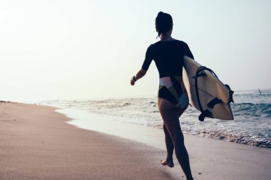 Sörfçü kadın tropik sahilde yürüyüş surfboard ile 