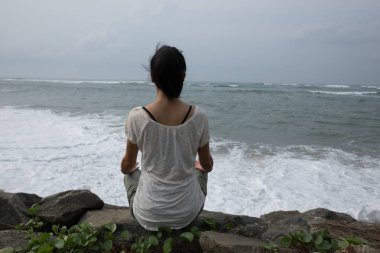 Devam et, meditasyon kavramı deniz kenarında oturan yoga kadın