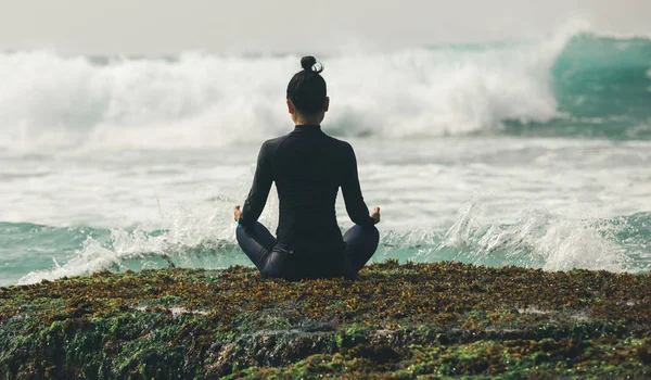 Молодая Женщина Медитирует Береговой Скалы Обращенной Грядущим Сильным Морским Волнам — стоковое фото