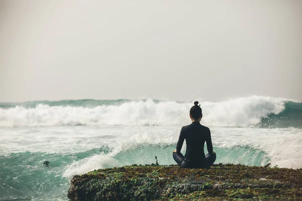 Молодая Женщина Медитирует Береговой Скалы Обращенной Грядущим Сильным Морским Волнам — стоковое фото