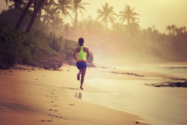 健身健康生活方式的概念 年轻女子在早晨日出时在热带海滩上跑步 — 图库照片