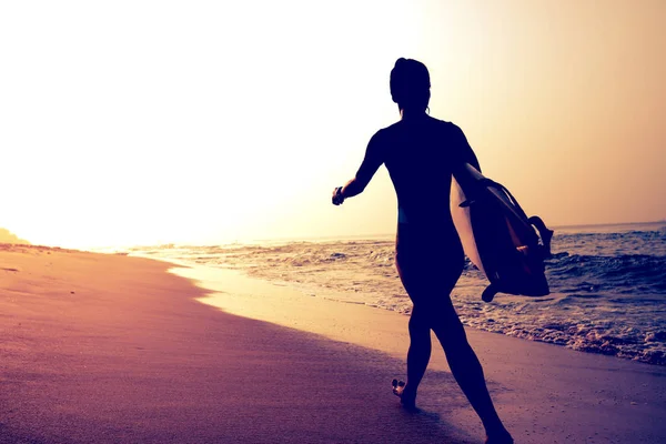サーファー サーフボードの熱帯のビーチの上を歩く女性 — ストック写真