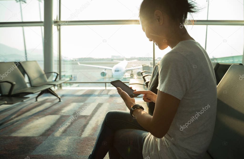 Young woman using mobile phone in airport