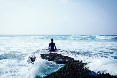 Genç kadın karşı karşıya gelen dalgalar güçlü deniz sahil uçurumun kenarında meditasyon