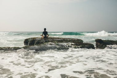 Genç kadın karşı karşıya gelen dalgalar güçlü deniz sahil uçurumun kenarında meditasyon