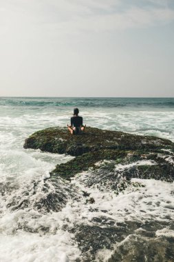 Genç kadın karşı karşıya gelen dalgalar güçlü deniz sahil uçurumun kenarında meditasyon