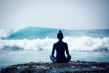 Genç kadın karşı karşıya gelen dalgalar güçlü deniz sahil uçurumun kenarında meditasyon