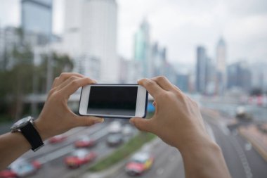 Cep telefonunuzun ve bulanık cityscape arka plan üzerinde eller 