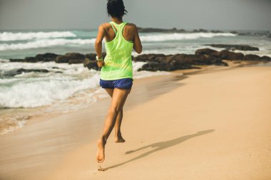 Fitness sağlıklı yaşam konsepti, tropik sahilde sabah gündoğumu sırasında çalışan genç kadın