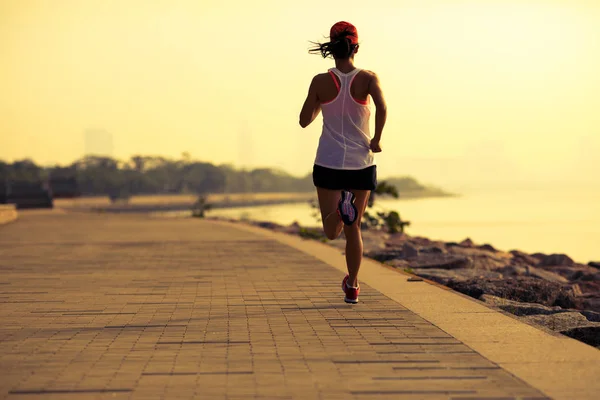 健身运动员在阳光明媚的海岸上奔跑 — 图库照片