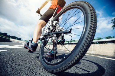 Genç kadın bisikletçi dağ bisiklet sürme karayolu üzerinde