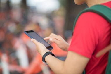 Akıllı telefon kullanan eller, şehirdeki paylaşılan motorun QR kodunu tarıyor