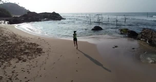 健身健康生活方式的概念 年轻女子在早晨日出时在热带海滩上跑步 — 图库视频影像