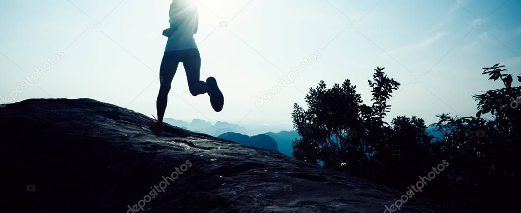 young fitness woman trail runner running to mountain top