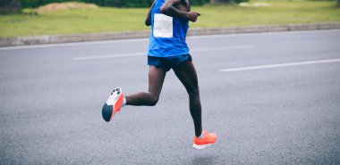 Şehir yolunda koşan maraton koşucusu bacakları