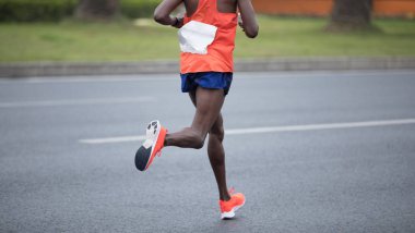 Şehir yolunda koşan maraton koşucusu bacakları