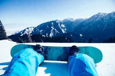 Kış zirvesinde snowboard yapan bir snowboardcu.