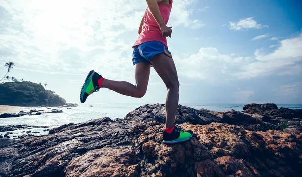 海辺でロッキー マウンテン トップへ実行している若いフィットネス女性トレイル ランナー — ストック写真
