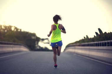 Şehir yolda çalışan genç kadın runner