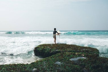 Kadın sörfçü yosunlu sahil mercan kayalıkları üzerinde sörf sörf going ile