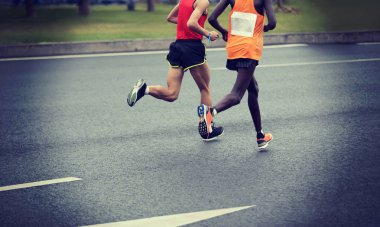 Şehir yolunda koşan maraton koşucusu bacakları