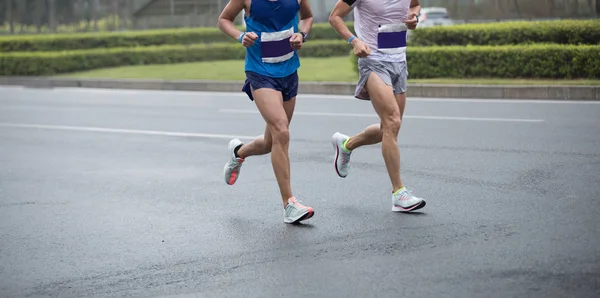 Marathon runner legs running on city road