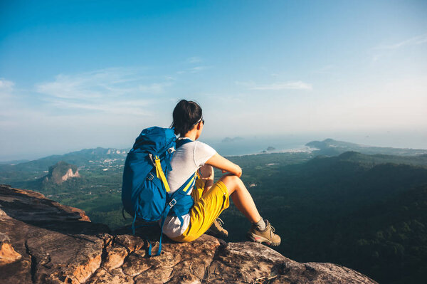 successful woman hiker enjoying view from mountain peak