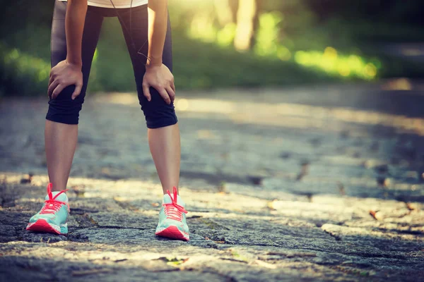 Yorgun bayan koşucu kırsal yolda koştuktan sonra dinleniyor. Country Road 'da maraton koşusundan sonra terli sporcu. 