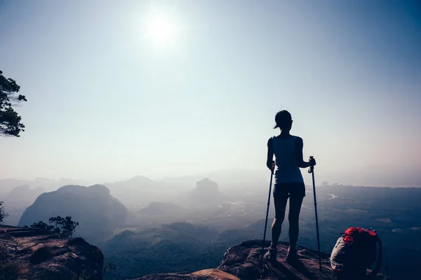 successful hiker standing on sunset mountain peak