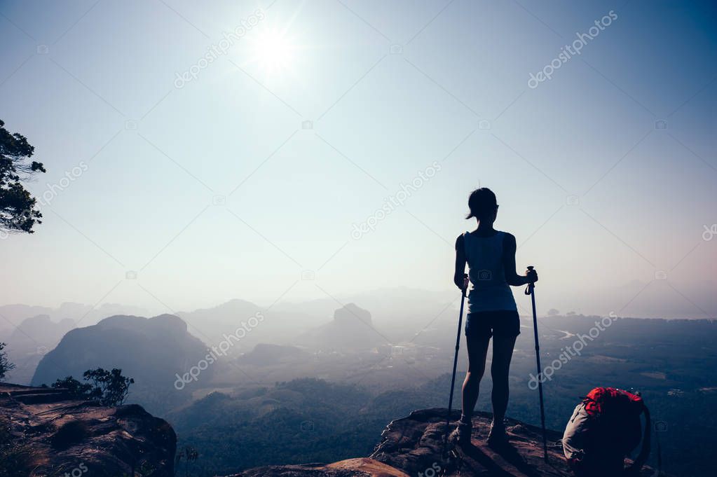 successful hiker standing on sunset mountain peak