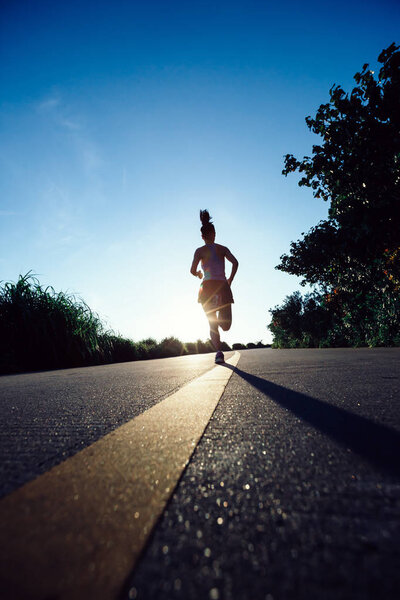 Fitness woman running on seaside trail in the morning
