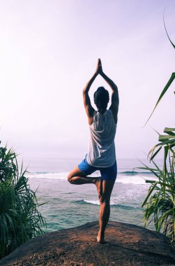 Kaya üzerinde sahilde Yoga pratik kadın 