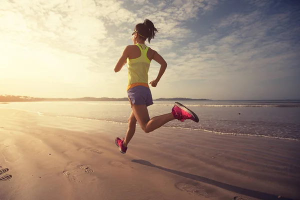 年轻的健康女子在日出时分在海滩上奔跑 — 图库照片