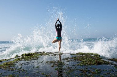 Pratik yoga sahil mercan uçurumun kenarında genç kadın