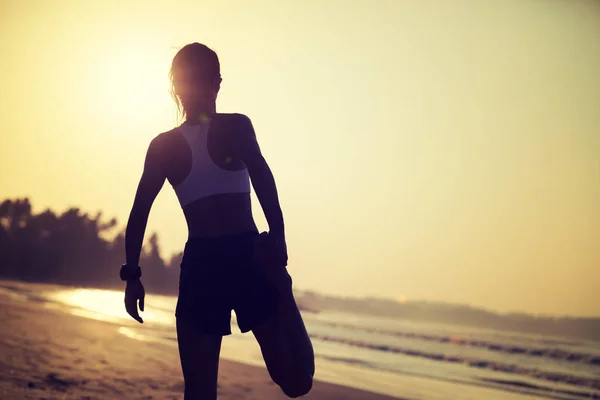 女运动员在日出海滩上热身 — 图库照片