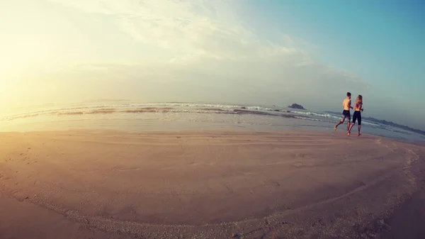 Unrecognizable people running on sandy beach of Sri Lanka