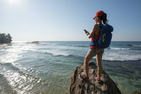 Γυναίκα Πεζοπόρος Στο Seaside Χρησιμοποιώντας Smartphone — Φωτογραφία Αρχείου