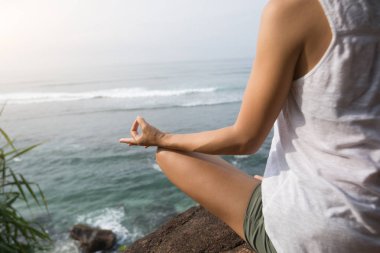 Kaya üzerinde sahilde Yoga pratik kadın 