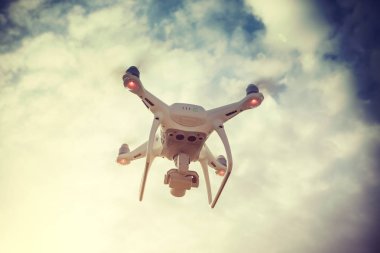 Bulutlu gökyüzünün altında havada uçan drone