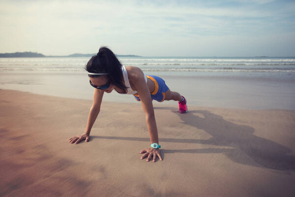 Фитнес азиатская женщина делает отжимания на пляже, концепция здорового образа жизни
