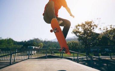 Skateboarder skateboarding at skate park ramp clipart