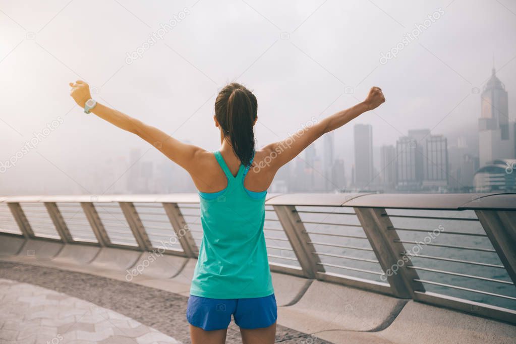 Healthy lifestyle, woman runner with outstretched arms on foggy city morning