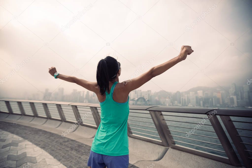 Healthy lifestyle, woman runner with outstretched arms on foggy city morning