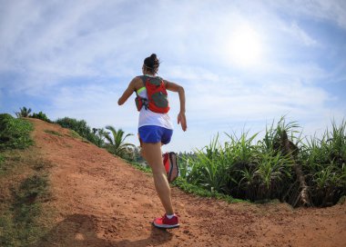 Sahil tepelerinde koşan kadın iz koşucusu