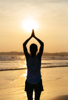 Kadın pracicing yoga sunset Beach arkadan görünüş