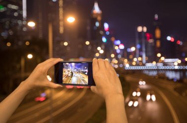 Hong Kong gece fotoğraf çekmek için akıllı telefon kullanarak eller