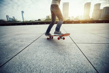 Şehir merkezinde gün doğumunda kaykay kaykay 