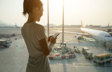 Havaalanında cep telefonu kullanan bir kadın.