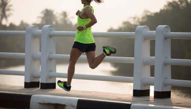 Kadın koşucu dışarıda koşuyor. Sportif insanlar antrenman yapıyor. Sağlıklı yaşam tarzı ve spor kavramları